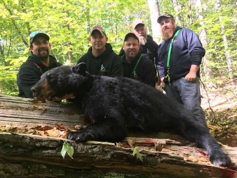 Hunters gathered with a black bear