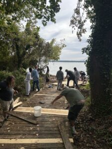 The boardwalk taking shape through the trees toward the water